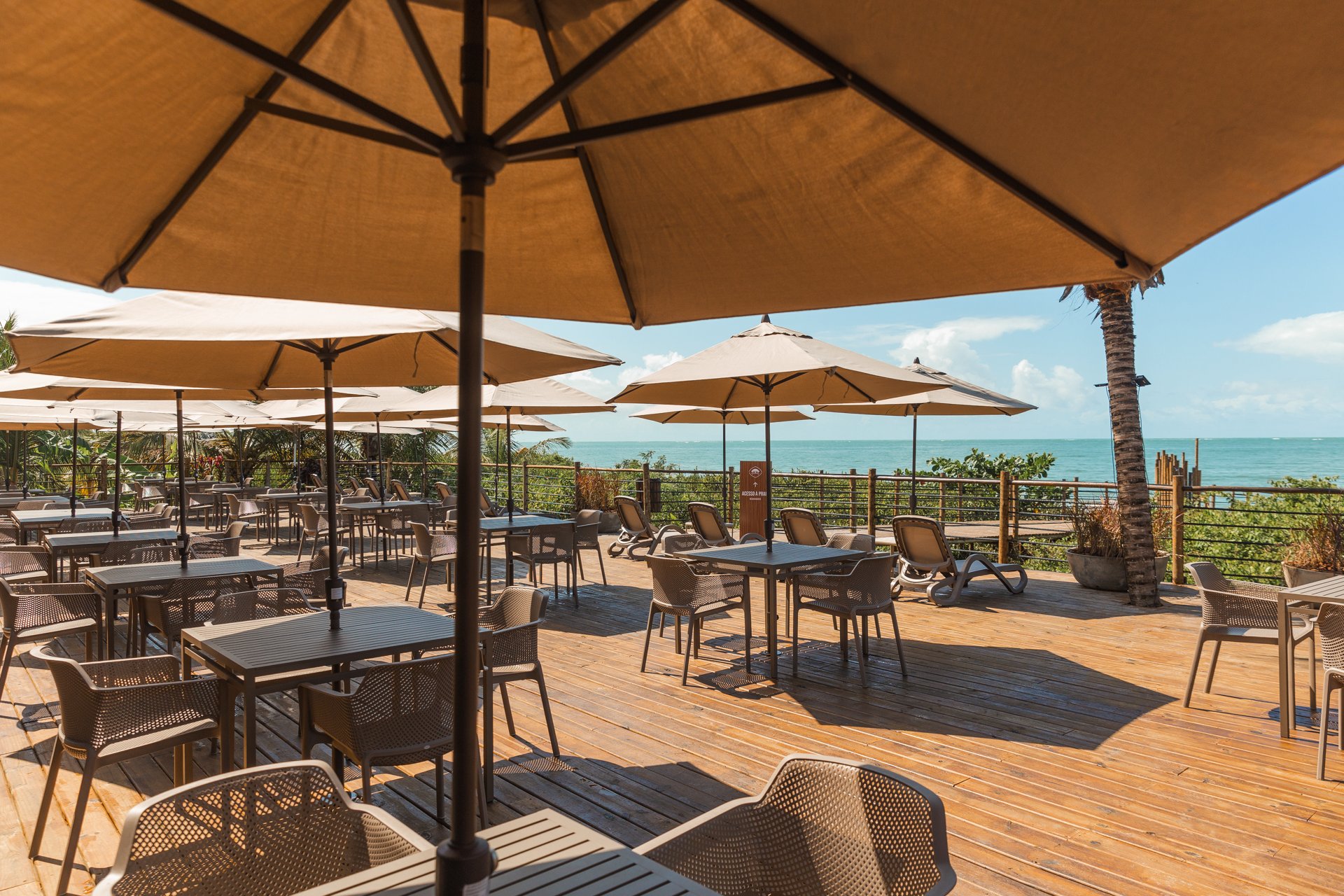 Deck com guarda-sóis e vista para o mar no Lontra Beach Club