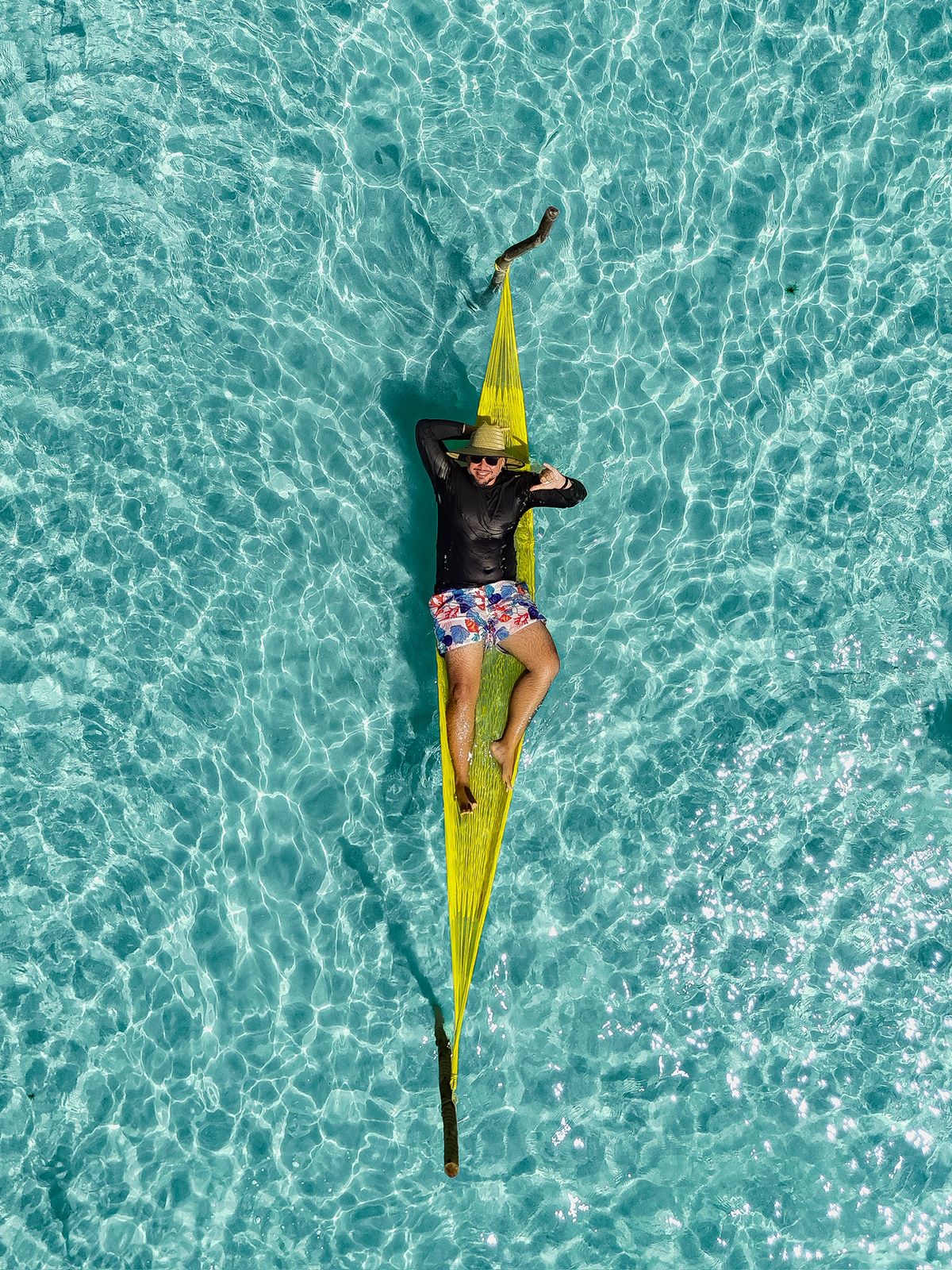 Leo Viana guia turístico relaxando em rede sobre o mar cristalino de Alagoas